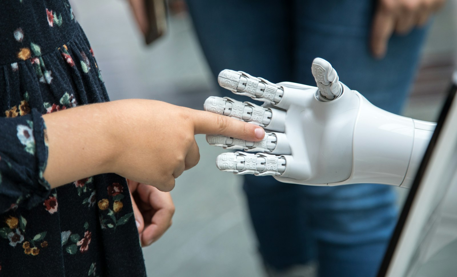 Mano humana tocando una mano robótica blanca, simbolizando marketing con IA frente al tradicional