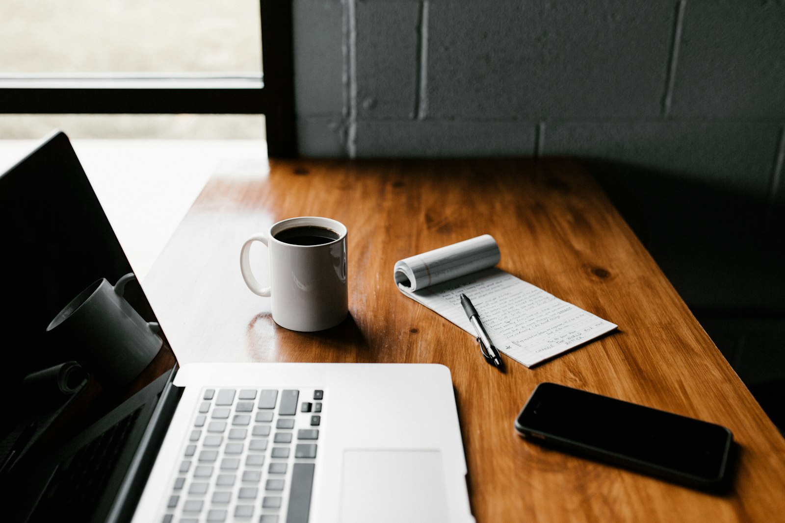 Escritorio con laptop y notas durante la revisión de una auditoría de marketing digital