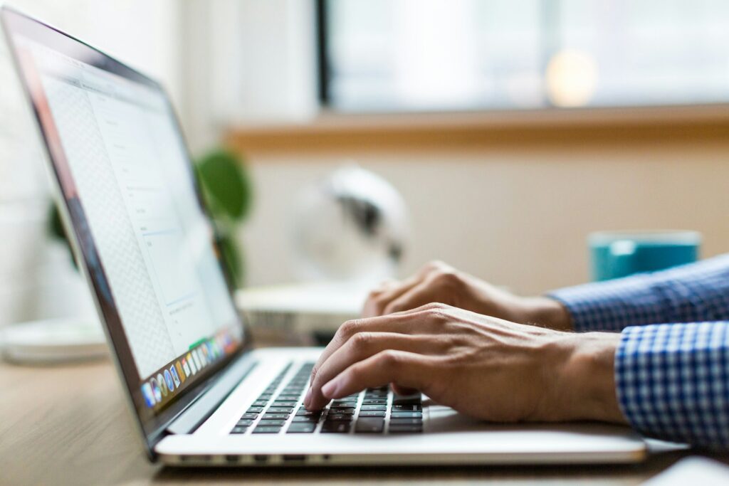 Persona escribiendo en una laptop, representando comunicación personalizada y automatización de marketing
