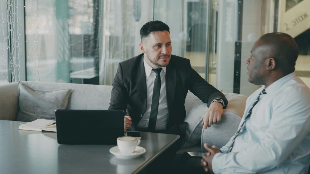 Dos profesionales conversando sobre estrategia de negocio con una tablet, como en una asesoría de marketing