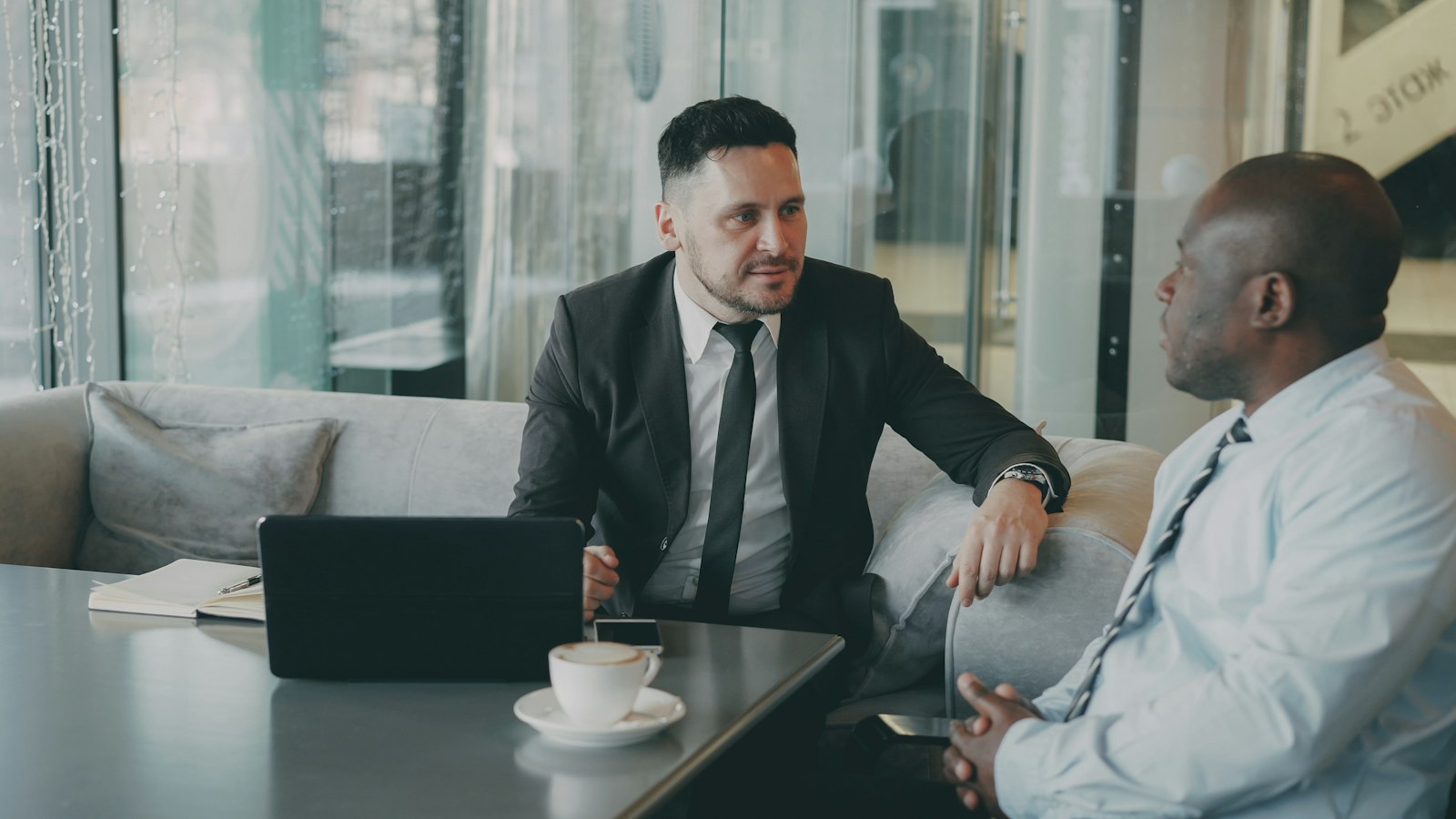 Dos profesionales conversando sobre estrategia de negocio con una tablet, como en una asesoría de marketing